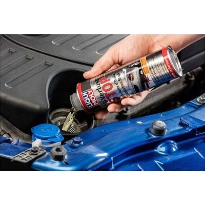 Pessoa a verter líquido LIQUI MOLY Metropol PROTECTION num motor de carro azul