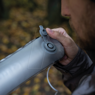 Garrafa desportiva cinzenta com tampa deslizante segurada à mão