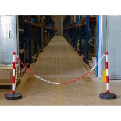 Estacas vermelhas e brancas com corrente bloqueando corredor num armazém