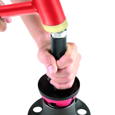 Mão segurando peça metálica preta com base circular e peça vermelha com ponta amarela