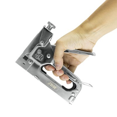 Grampeador de aço prateado JBM na mão sobre fundo branco