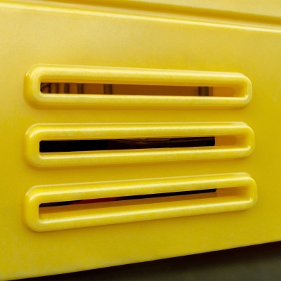 Superfície amarela com três aberturas horizontais retangulares e bordas arredondadas