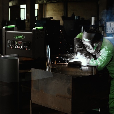 Pessoa a soldar chapa metálica com máquina JBM num ambiente industrial