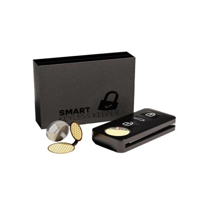 Dispositivo preto com dois botões, etiquetas redondas douradas e caixa preta SMART KEYLESS KEEPER.