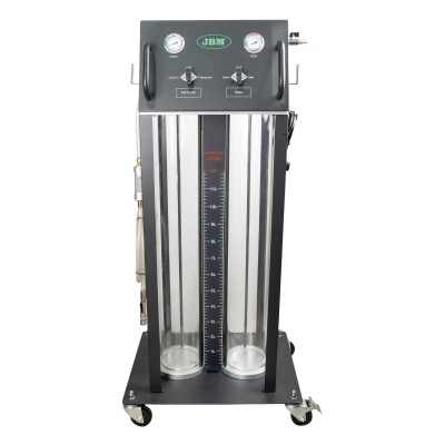 Equipamento industrial preto com cilindros transparentes verticais e manómetros, sobre rodas.