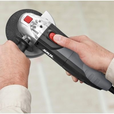 Rebarbadora elétrica preta e cinza com detalhes em vermelho, marca SKIL, segurada por duas mãos