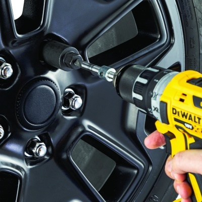 Roda preta de carro com parafusos e chave de impacto amarela DEWALT a apertar parafuso