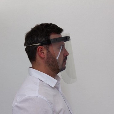 Homem de perfil com viseira de proteção transparente e camisa branca