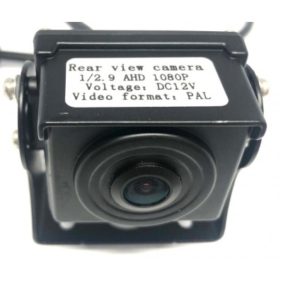 Câmara de visão traseira preta com lente circular e etiqueta com especificações técnicas.