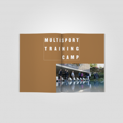 Livro aberto com capa castanha e fotografia de pessoas junto a piscina com texto 