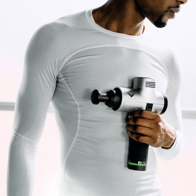 Homem com camisa branca usando massageador muscular cinza no peito