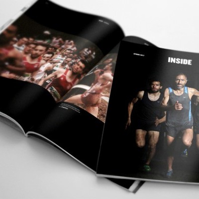 Revista aberta mostrando três corredores homens em roupa preta e texto 'INSIDE'