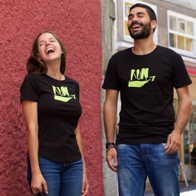 Três pessoas com t-shirts RUN e jeans junto a parede vermelha e amarela