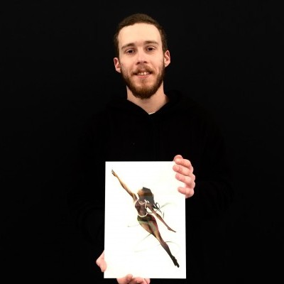 Homem com camisola preta a segurar um quadro com imagem de mulher a saltar.