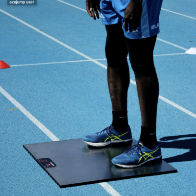 Plataforma de medição digital com ecrã em pista de corrida azul e pessoa com roupa desportiva