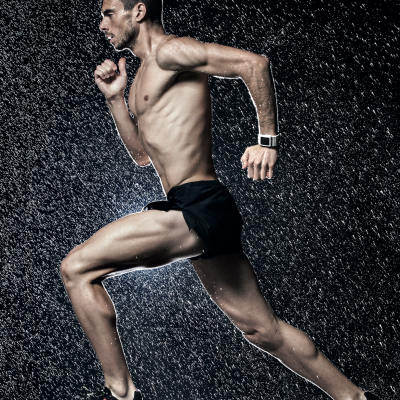 Homem a correr na chuva com calções pretos, ténis rosa e relógio digital branco