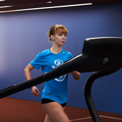 Mulher correndo numa passadeira numa academia