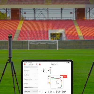 Campo de futebol com câmaras em tripés e tablet exibindo plano tático