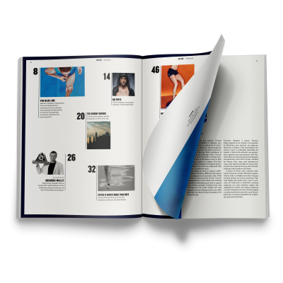 Revista aberta com fotografias, textos e páginas numeradas visíveis.