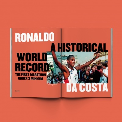 Revista aberta com artigo sobre Ronaldo Da Costa e recorde de maratona, fundo laranja