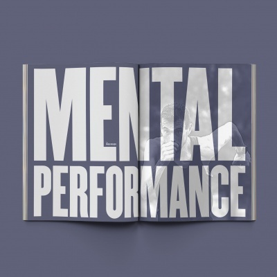 Revista aberta com texto 'MENTAL PERFORMANCE' em letras grandes e brancas
