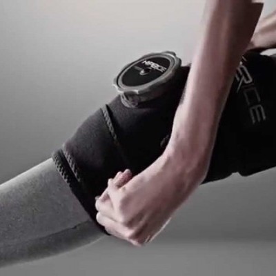 Joelheira preta com dispositivo digital no joelho de pessoa em roupa desportiva cinzenta