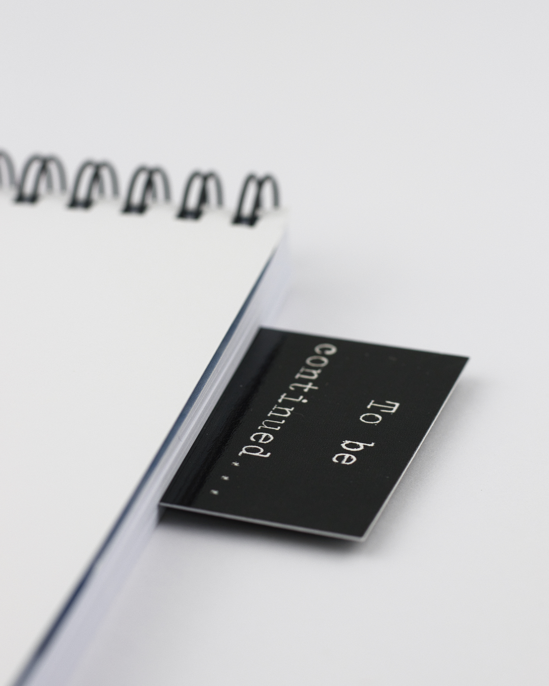 Caderno branco com argolas e separador preto com texto