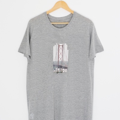 T-shirt cinzenta com estampa central colorida pendurada num cabide de madeira