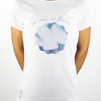 T-shirt branca com estampa azul e texto 'no rain no flowers' vestida por mulher