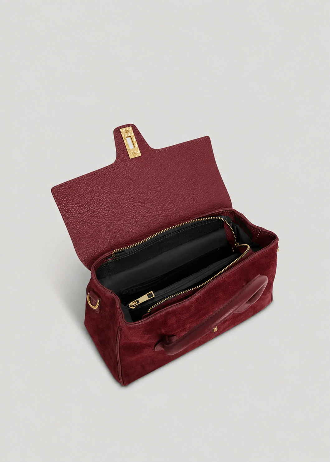 MALA EM PELE ITALIANA VOLTERRA BURGUNDY | TUSCAN Mala de mão vermelha aberta mostrando interior preto e fechos dourados
