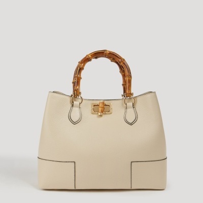 Mala creme com alças de bambu e fecho dourado