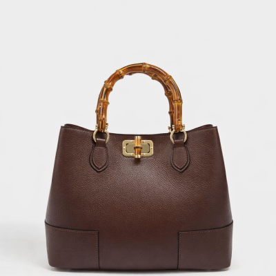 Mala de mão castanha com pega de bambu e fecho dourado