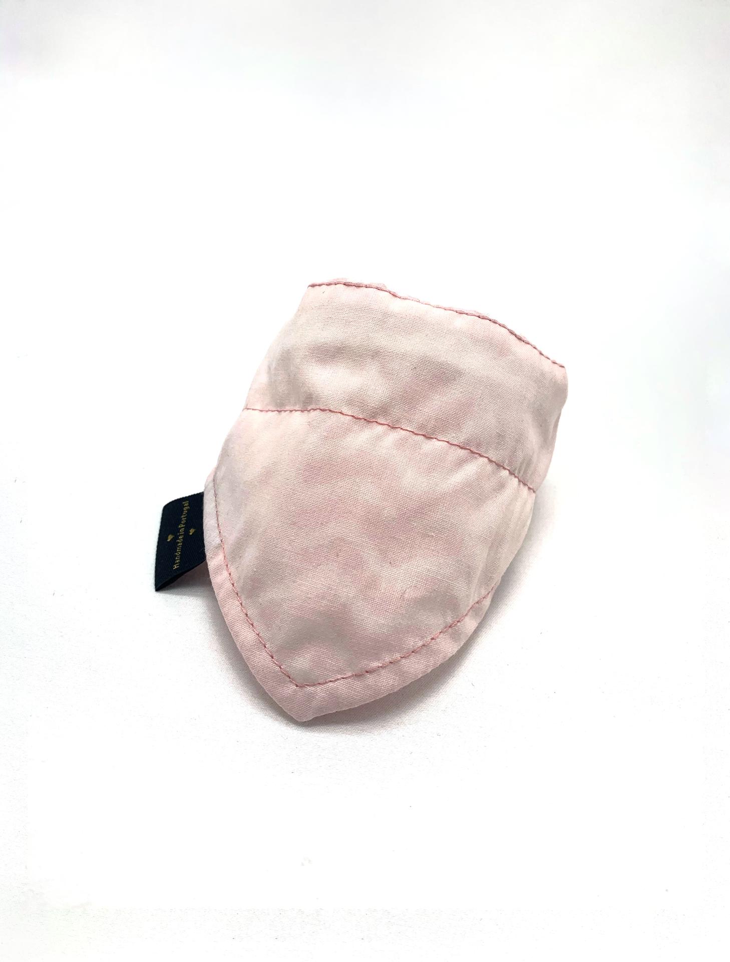 Protetor acolchoado rosa claro com etiqueta preta sobre fundo branco