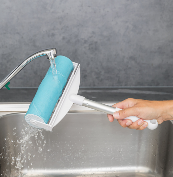 Rolo de limpeza azul com pega branca sob torneira na pia da cozinha