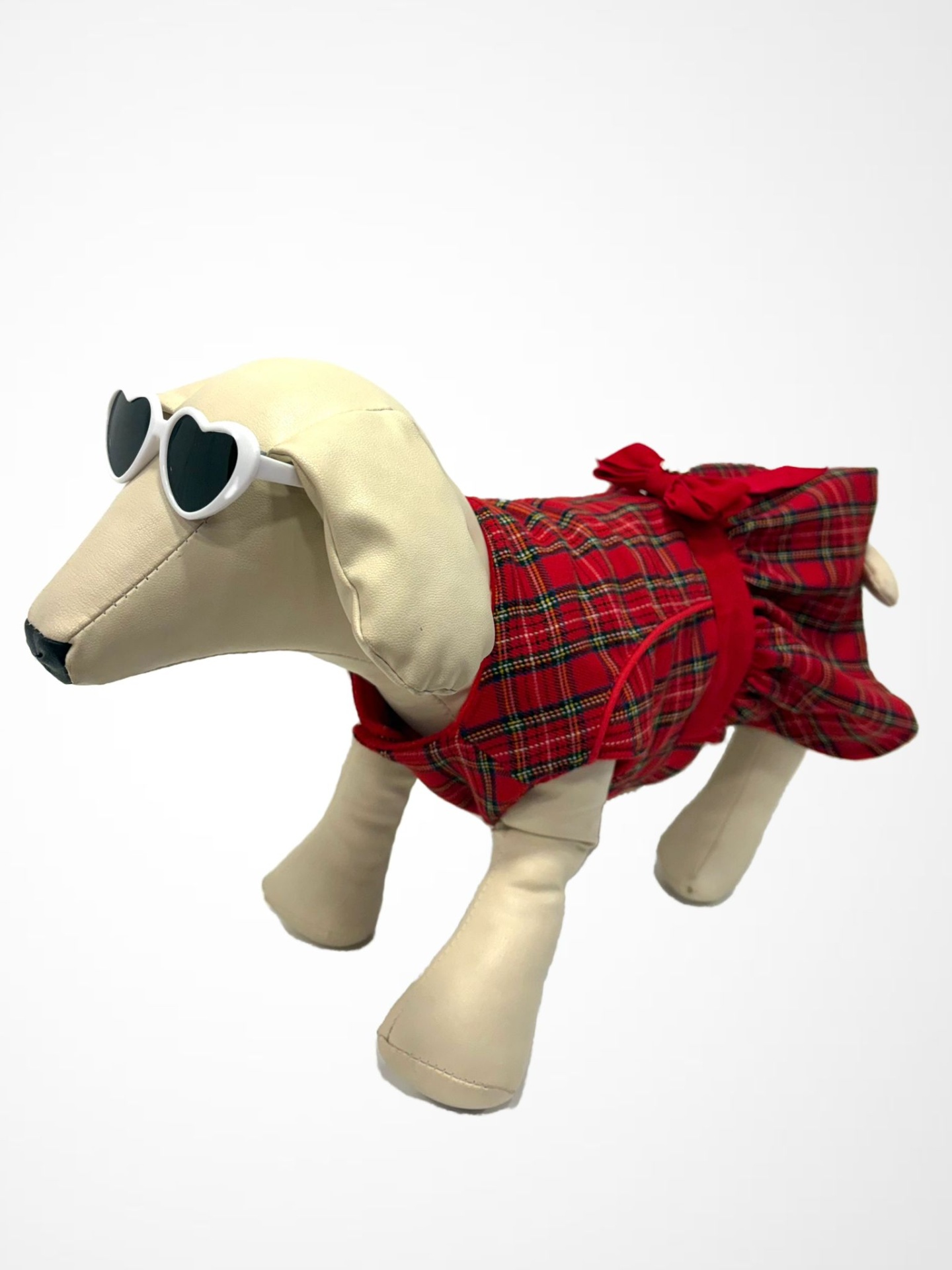 Estátua de cão creme com óculos de sol e vestido xadrez vermelho