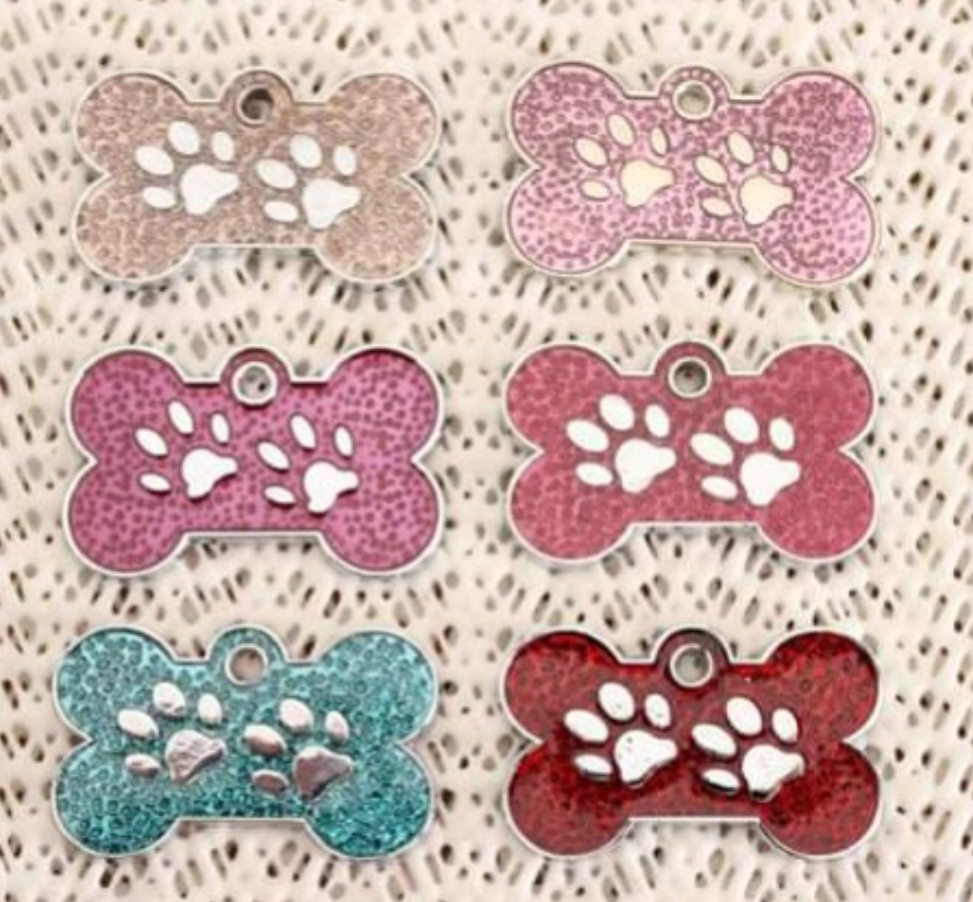 Seis medalhas para animais em forma de osso com estampas de patas, em várias cores e textura marmoreada