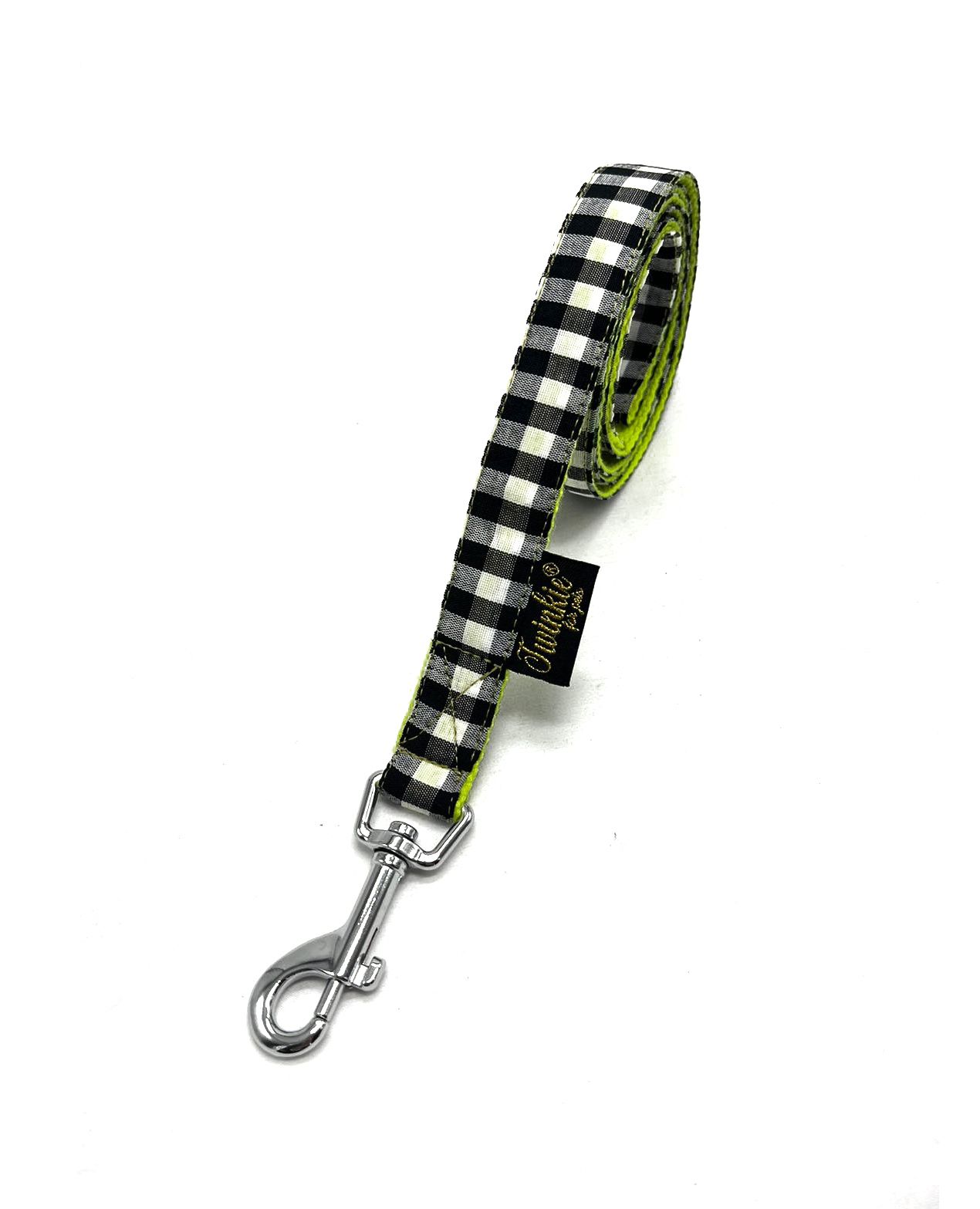 Trela para animais padrão xadrez preto e branco com interior verde e fecho metálico.