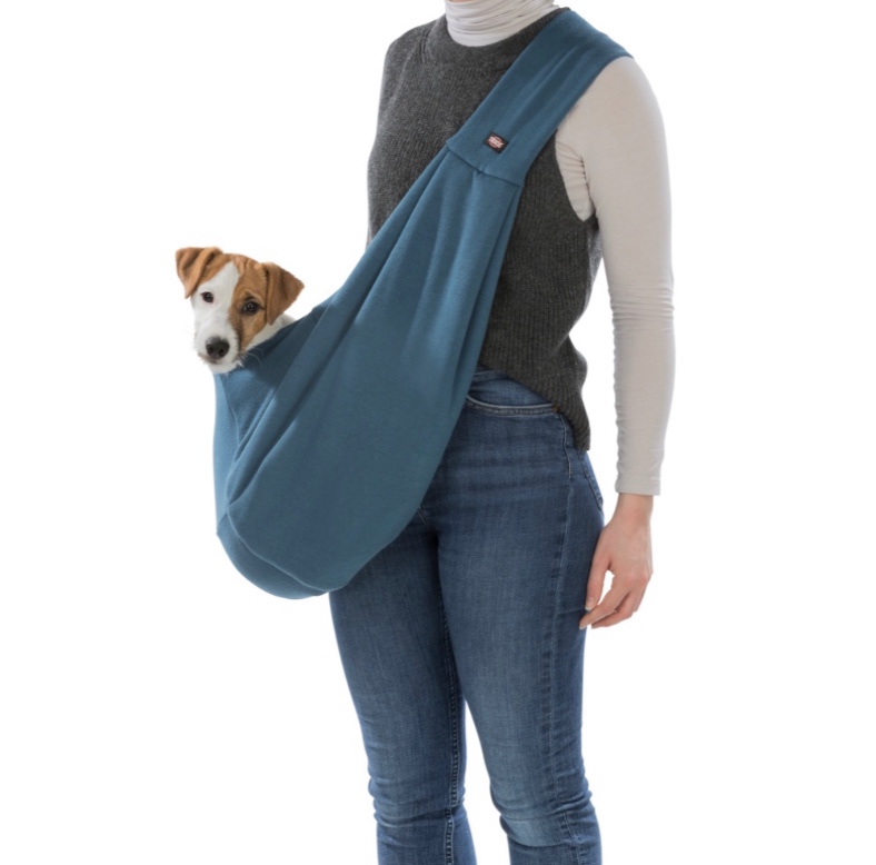 Pessoa com saco sling azul e cão pequeno dentro