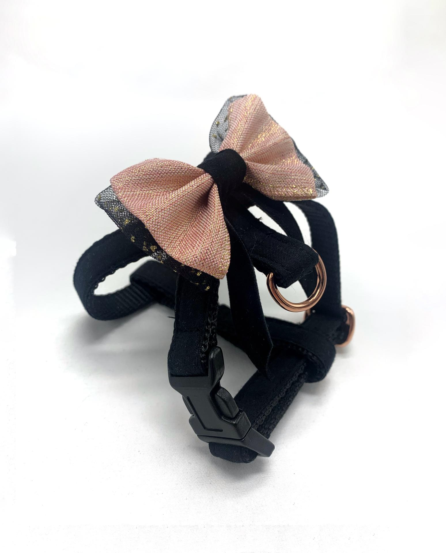 Peitoral para cão preto com laço rosa e tule preto com pontos dourados.