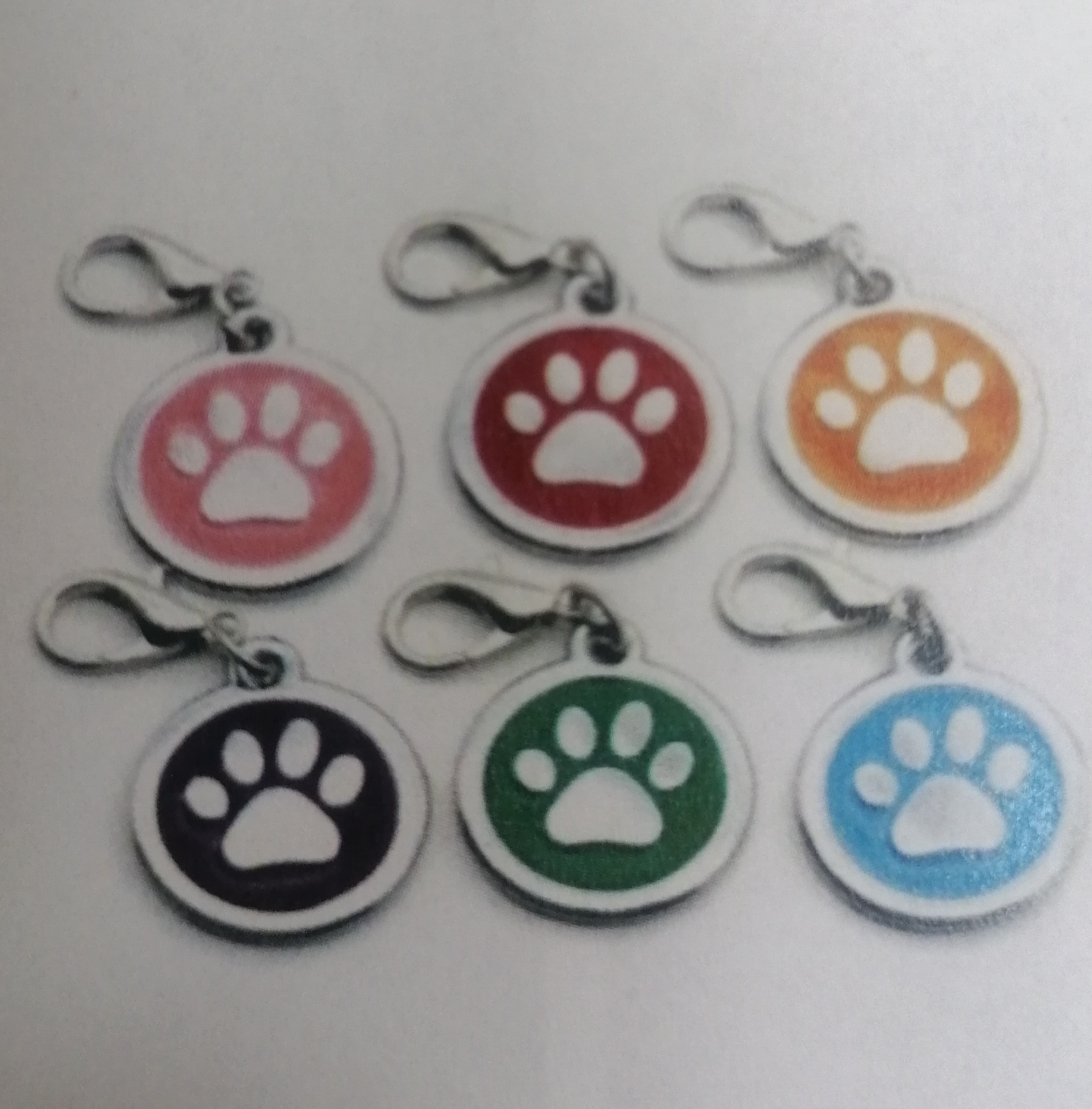 Seis porta-chaves com desenhos de patas coloridas e fechos metálicos.