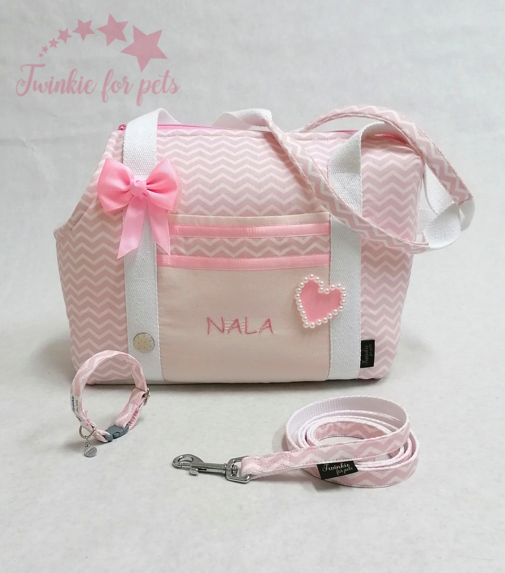 Conjunto rosa para animais com mala, trela e coleira e decoração de laço e coração.
