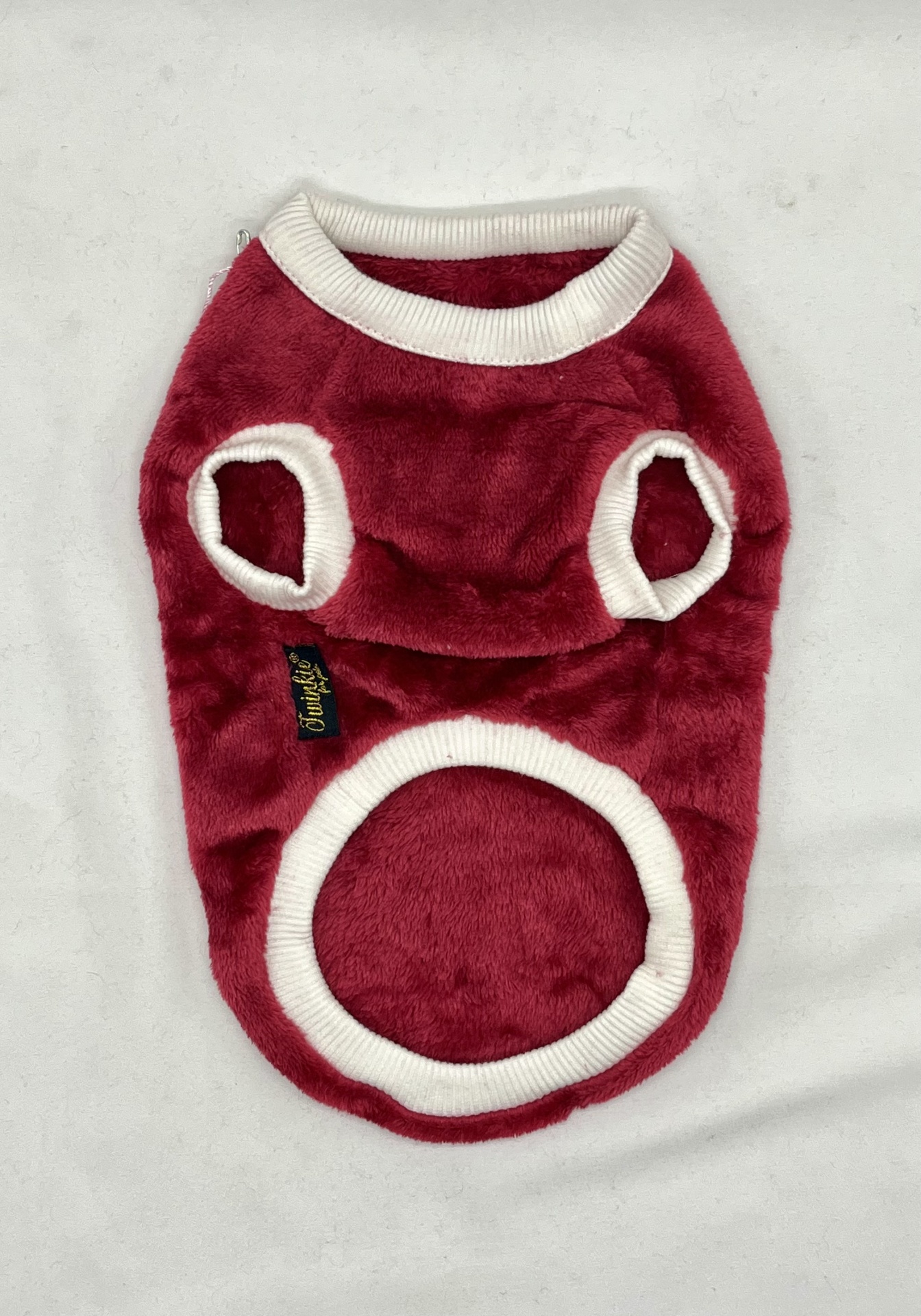 Roupa felpuda vermelha com detalhes brancos para cão sobre fundo branco