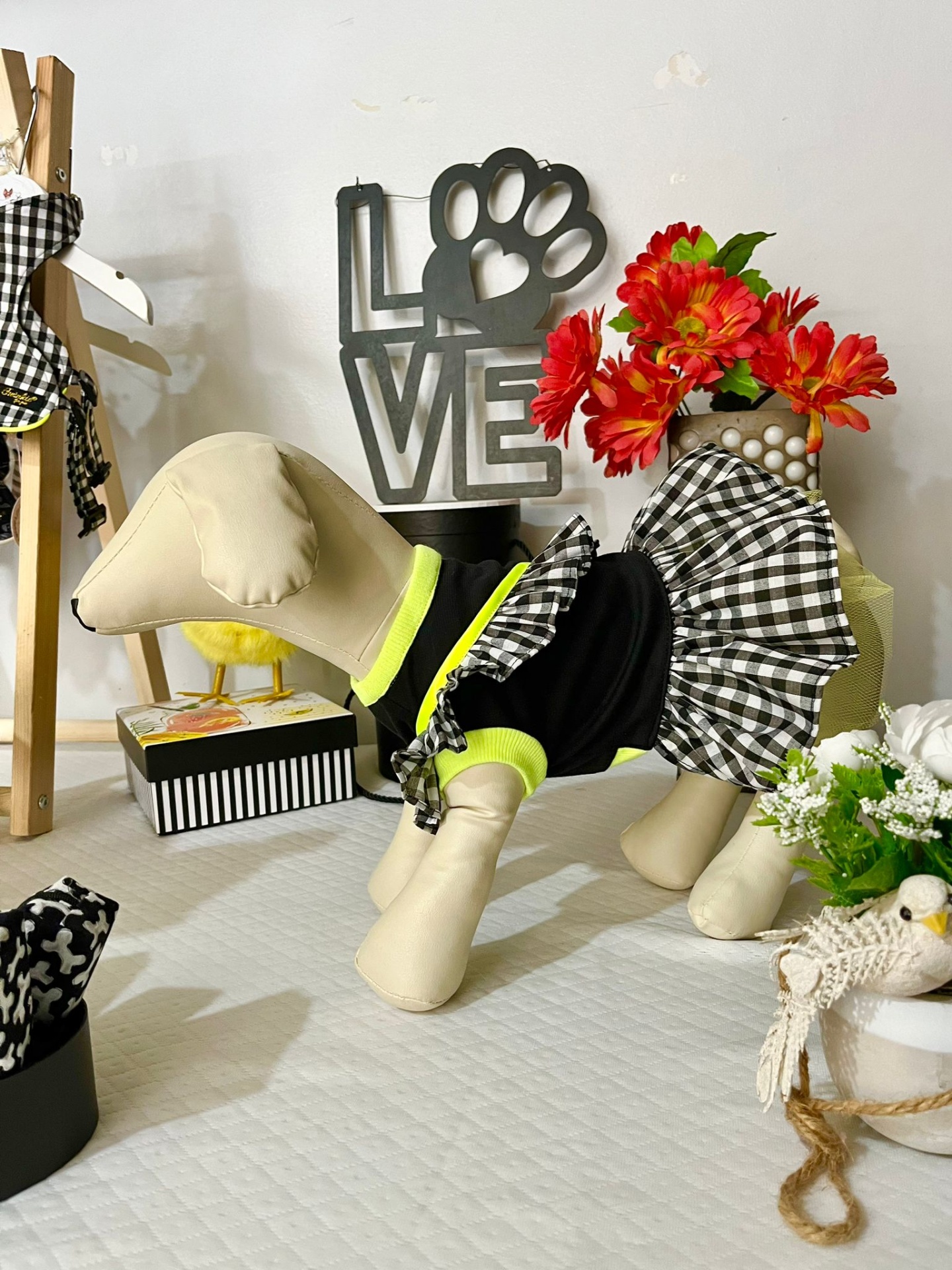 Estátua de cão em roupa preta e saia xadrez em ambiente decorado