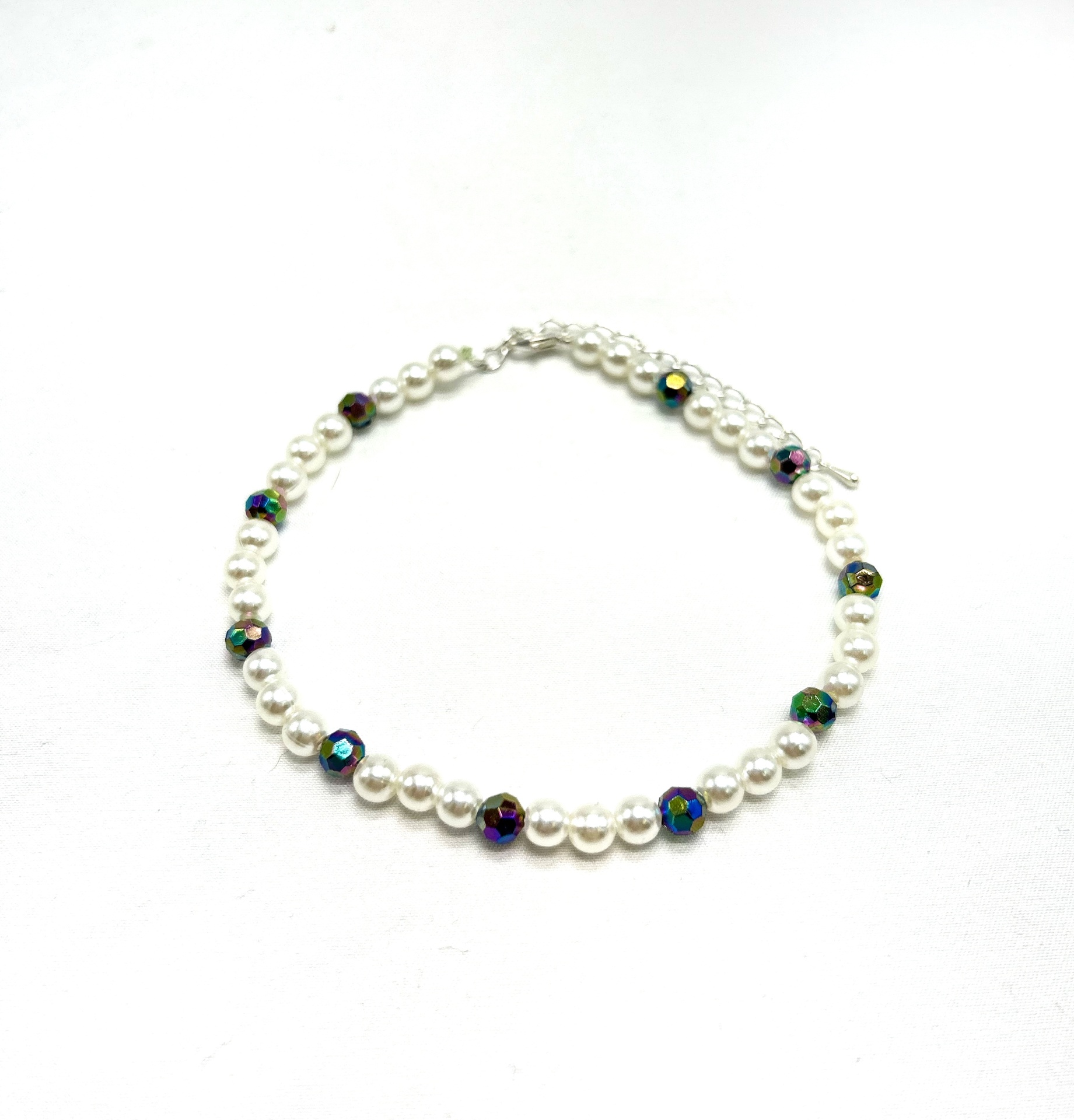 pulseira de pérolas brancas com contas multicoloridas sobre fundo branco