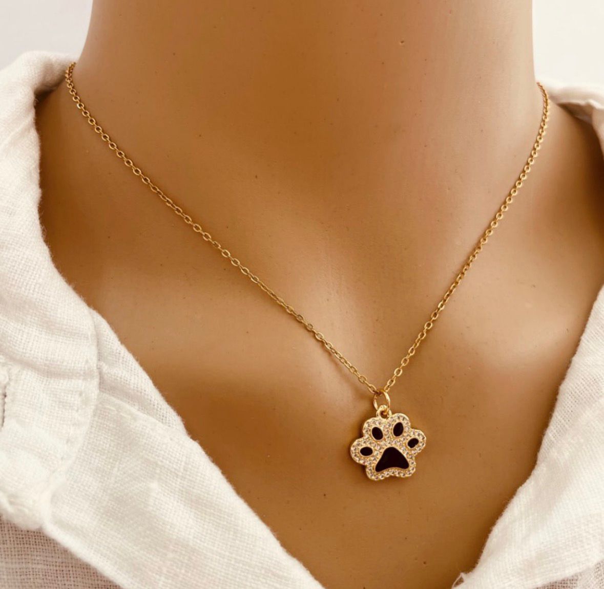 Colar dourado com pendente em forma de pata de animal