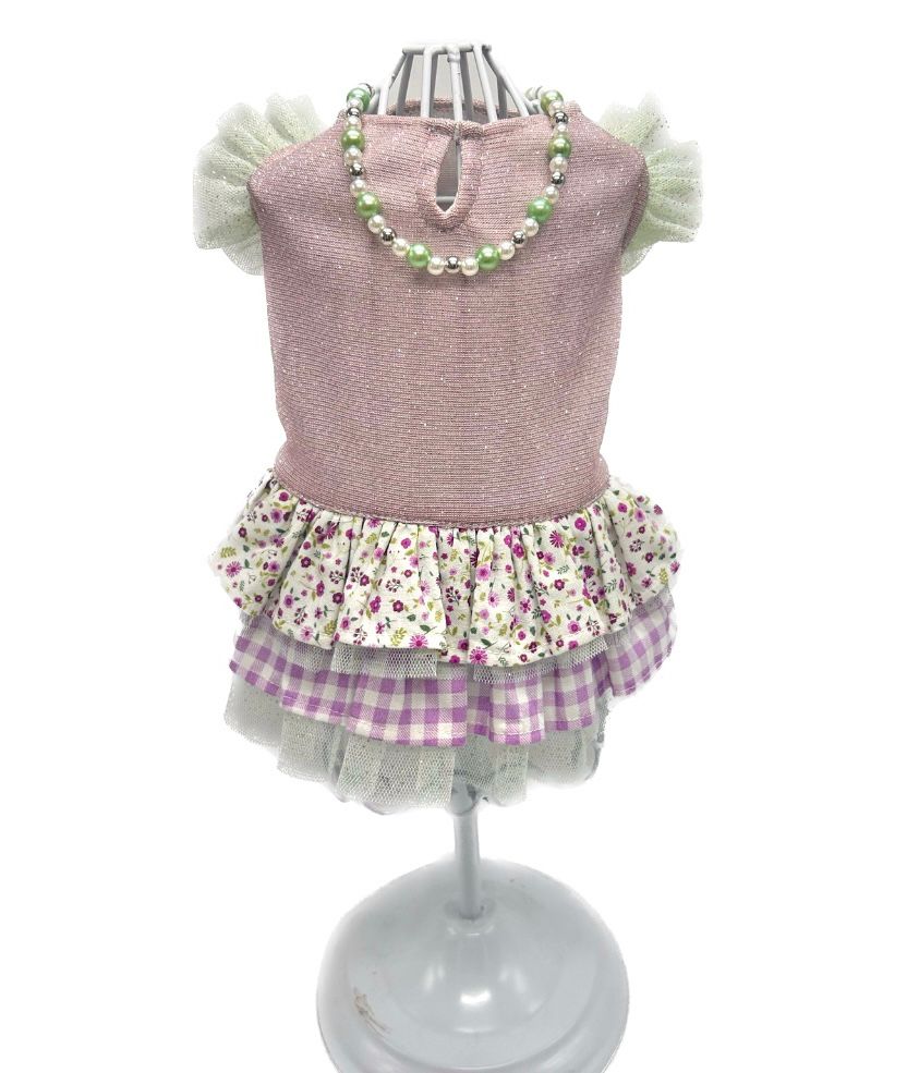 Vestido rosa de criança com saia floral e xadrez e colar de contas no manequim