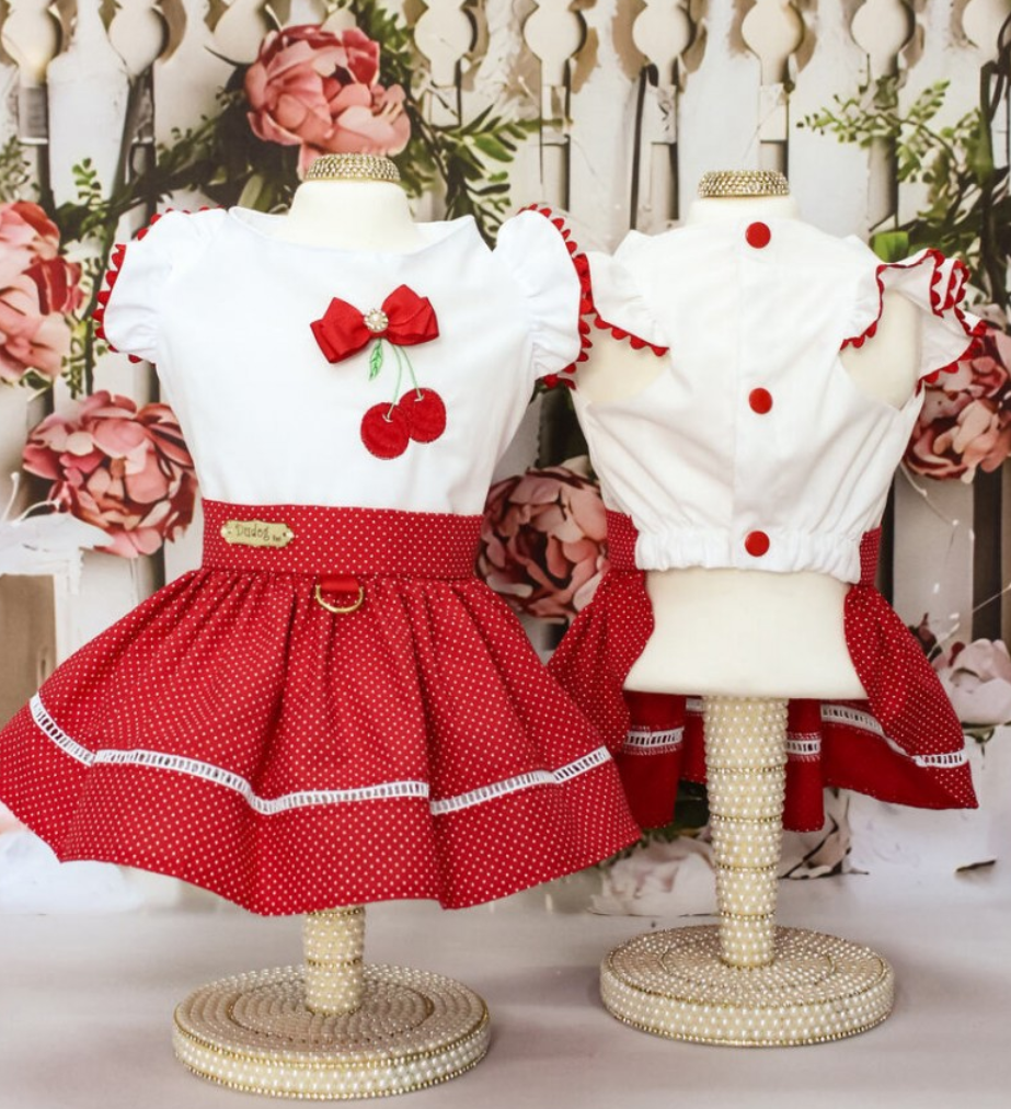 Vestido infantil vermelho e branco com laço, cerejas e saia de bolinhas em manequins