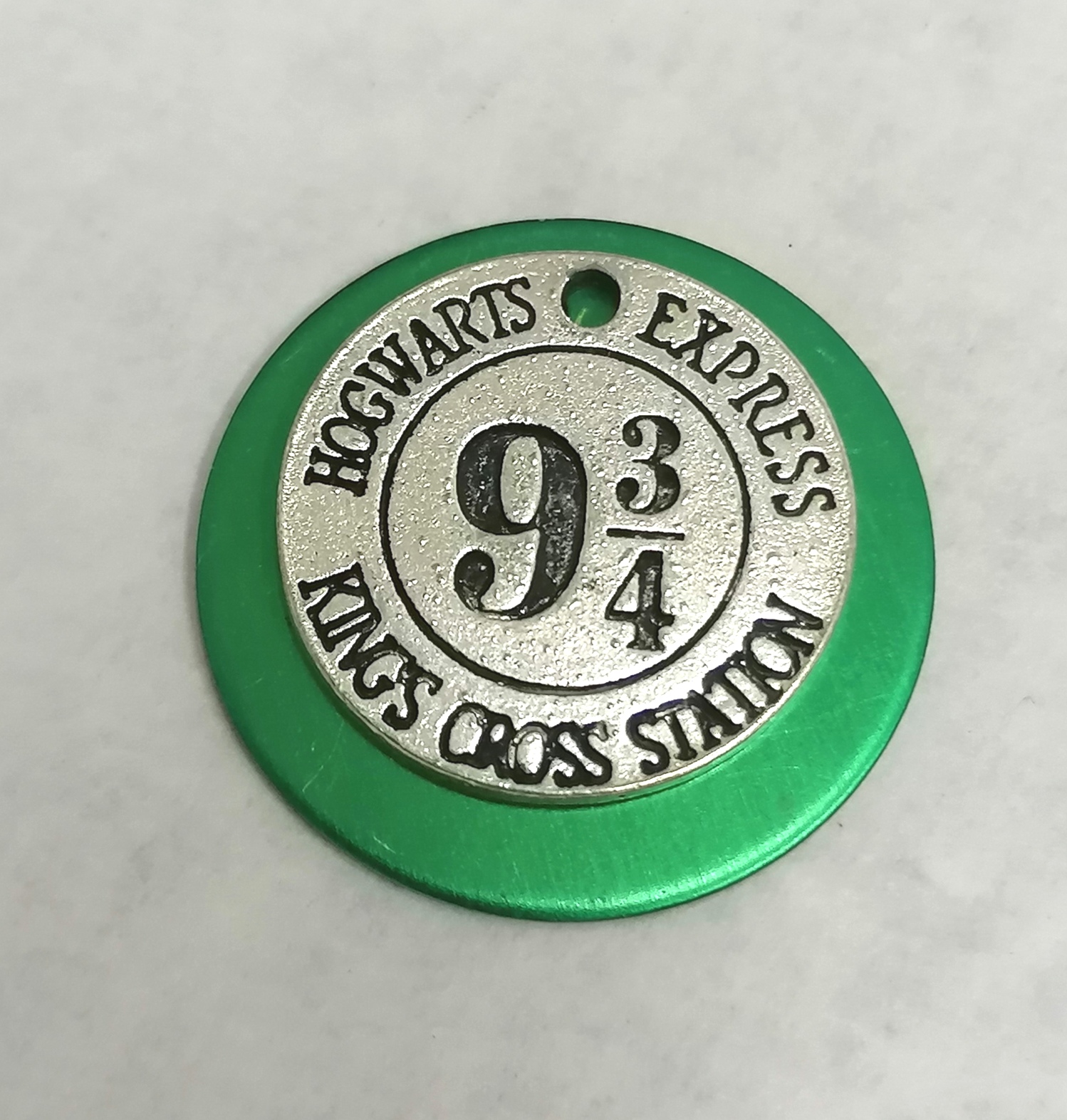 Disco metálico verde e prateado com texto Hogwarts Express 9 3/4