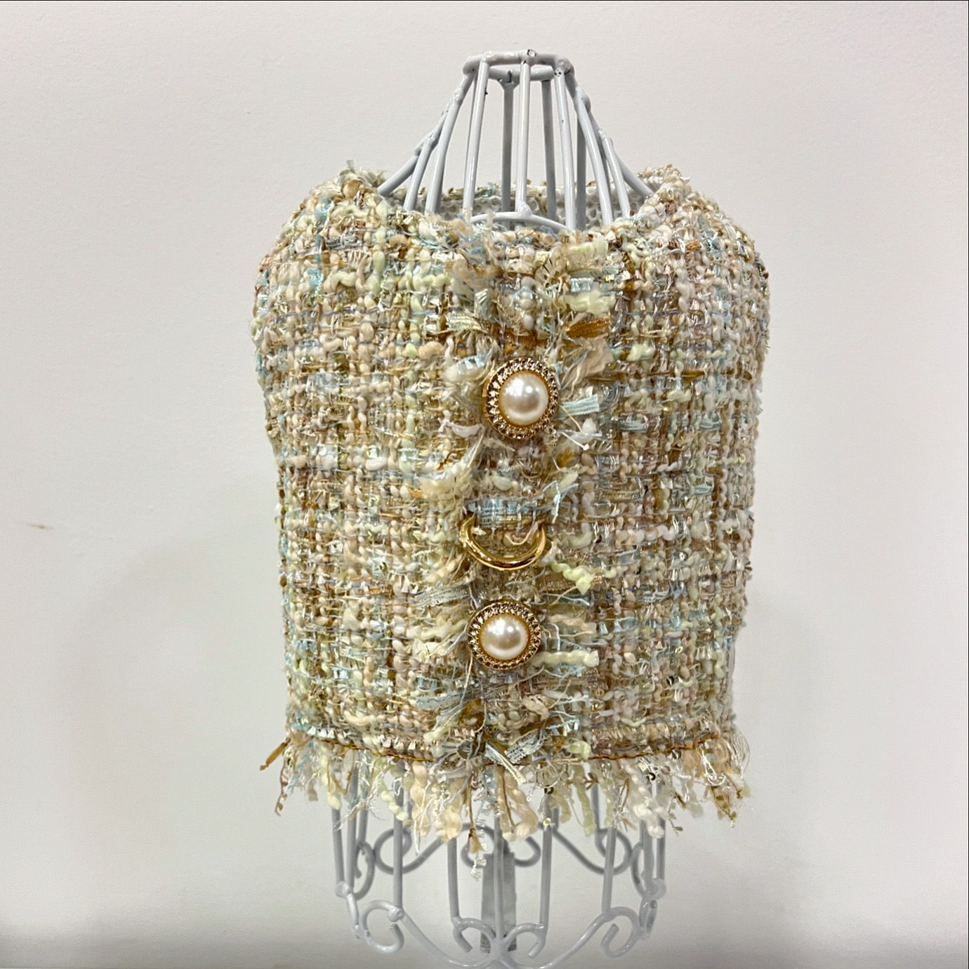 Top tweed bege com botões dourados e pérolas em manequim branco