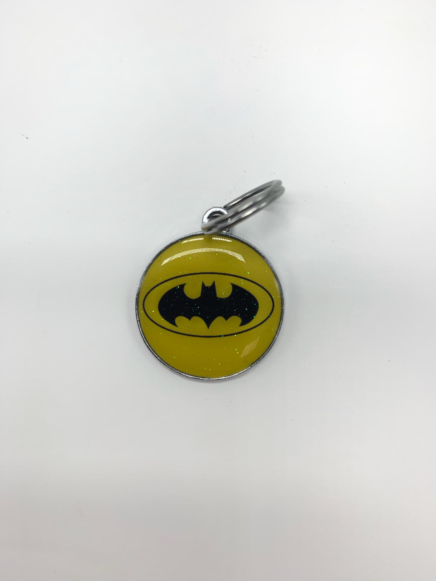 Chaveiro redondo amarelo com símbolo preto do Batman
